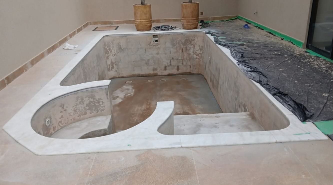 A mesma piscina antes da reforma, vazia e sem revestimento